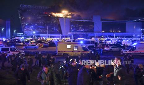 Seorang pria berbicara kepada wartawan saat kobaran api besar terlihat di Balai Kota Crocus di tepi barat Moskow, Rusia, Jumat,  (22/3/2024).