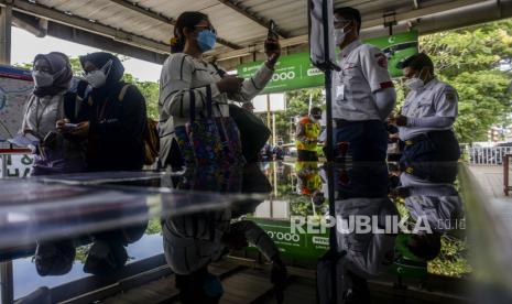 Calon penumpang memindai kode batang (QR Code) untuk menaiki KRL di Stasiun Manggarai, Jakarta, Senin (6/9). PT KAI Commuter mulai melakukan uji coba penggunaan aplikasi PeduliLindungi bagi pengguna KRL di 11 stasiun. Republika/Putra M. Akbar