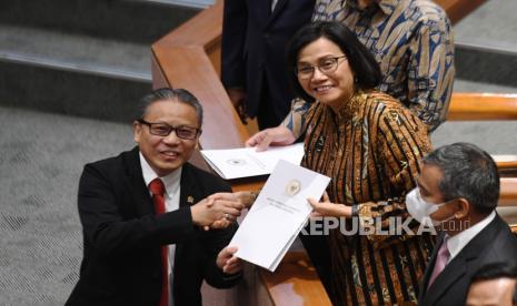 Menteri Keuangan Sri Mulyani Indrawati (kanan) menerima berkas hasil rapat dan pandangan mini fraksi dari Ketua Panja pembahasan Rancangan Undang-Undang (RUU) tentang Pengembangan dan Penguatan Sektor Keuangan (PPSK) Dolfie OFP (kiri) saat rapat paripurna di Kompleks Parlemen, Senayan, Jakarta. Indonesia Fintech Society (IFSOC) menyambut positif hasil rapat paripurna Dewan Perwakilan Rakyat (DPR) yang telah secara resmi mengesahkan Undang-Undang Pengembangan dan Penguatan Sektor Keuangan (UU PPSK). 