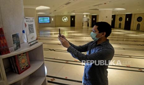 Seorang jamaah melakukan pembayaran Infaq menggunakan Quick Response Code Indonesian Standard (QRIS) Mandiri Syariah di Masjid Al-Ihsan BSM. Platform digital menjadi tumpuan dari penghimpunan zakat di masa pandemi. 