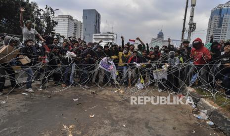 Massa menarik kawat barikade polisi saat aksi unjuk rasa tolak UU Cipta Kerja di kawasan Patung Kuda, Jakarta, Selasa (13/10/2020). 