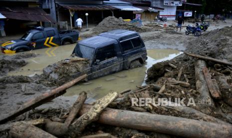 Kondisi rumah dan mobil yang tertimbun lumpur akibat terjangan banjir bandang di Kecamatan Masammba, Kabupaten Luwu Utara, Sulawesi Selatan, Rabu (15/7/2020). Banjir bandang yang terjadi akibat tingginya curah hujan tersebut mengakibatkan 16 orang meninggal dunia dan puluhan warga dilaporkan masih dalam pencarian, sementara ratusan rumah rusak berat dan hilang.