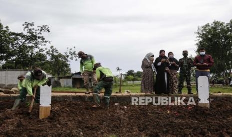 Penambahan kasus Covid 19 terus bertambah meski penerapan PSBB sudah dilakukan. Foto, para penggali kuburan mempersiapkan kuburan dan sebagian kerabat korban Covid-19 berdoa saat pemakaman (ilustrasi)