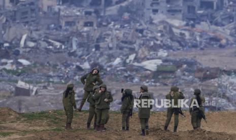 Seorang tentara wanita Israel berpose untuk difoto oleh tentara lain di perbatasan Jalur Gaza, di Israel selatan, Senin, 19 Februari 2024.