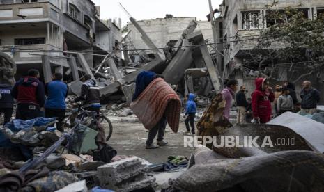 Warga Palestina memeriksa kerusakan bangunan tempat tinggal pasca serangan udara Israel di Rafah, Jalur Gaza selatan, Ahad, (24/3/2024).