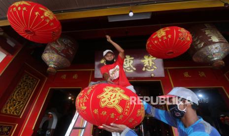 Pekerja memasang lampion di Klenteng Tjoe Hwie Kiong, Kota Kediri, Jawa Timur, Jumat (5/2/2021). Klenteng yang telah ditetapkan sebagai bangunan cagar budaya tersebut mulai memasang lampion untuk menyambut Tahun Baru Imlek 2572 yang jatuh pada 12 Februari mendatang. 