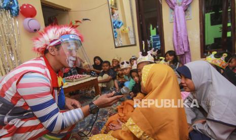 Seorang badut menggunakan alat pelindung wajah (face shield) saat menghibur di acara ulang tahun di Depok, Jawa Barat, Kamis (25/6/2020). Andra Badut sulap kembali mendapatkan panggilan di masa Pembatasan Sosial Berskala Besar (PSBB) Proporsional dengan tampil menggunakan alat pelindung wajah (face shield) sebagai salah satu upaya untuk melindungi diri sekaligus mencegah penyebaran COVID-19. 