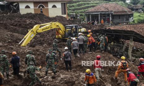 Recuers mencari korban longsor yang melanda sebuah desa di desa Cihanjuang, Jawa Barat, Indonesia, Selasa, 12 Januari 2021. Sejumlah orang tewas dan terluka dalam longsor yang dipicu oleh hujan deras pada hari Minggu di desa di Kabupaten Sumedang Jawa Barat. Beberapa korban merupakan penyelamat dari bencana longsor sebelumnya.