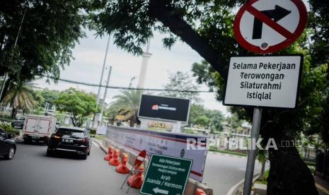 Pengendara melintas di dekat papan informasi penutupan jalan yang terpasang di kawasan Masjid Istiqlal, Jakarta, Jumat (22/1). 