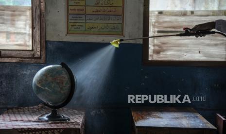 Petugas melakukan disinfeksi di sebuah kelas di SDN 065 Cihampelas yang ditutup sementara di Bandung, Jawa Barat, Senin (25/10/2021). Pemerintah Kota Bandung melalui Dinas Pendidikan menutup sementara 14 sekolah di Kota Bandung akibat temuan kasus COVID-19 hasil tes usap PCR secara acak di sejumlah sekolah. 