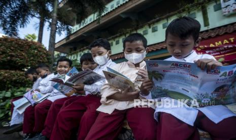 Sejumlah pelajar membaca buku bacaan koleksi mobil perpustakaan keliling di Halaman SDN Duren Sawit 06 dan 15 Pagi, Jakarta, Jumat (15/7/2022). Sudin Perpustakaan dan Kearsipan Kota Administrasi Jakarta Timur menyelenggarakan kegiatan Wisata Literasi bagi para pelajar di sekolah tersebut dengan menghadirkan mobil perpustakaan keliling bernama Si Armo yang bertujuan untuk meningkatkan kemampuan literasi membaca bagi pelajar di Jakarta. 