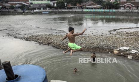 Seorang anak meloncat ke aliran Sungai Ciliwung Bendung Katulampa, Kota Bogor, Jawa Barat, Rabu (11/82021). Kurangnya lahan bermain serta minimnya pengawasan orang tua membuat anak-anak kerap bermain di tempat berbahaya yang berpotensi mengancam keselamatan mereka. 