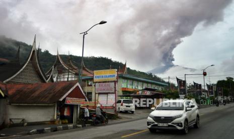 Kendaraan melintas saat Gunung Marapi mengeluarkan abu vulkanik terlihat di Padang Panjang, Sumatera Barat, Sabtu (30/12/2023). 