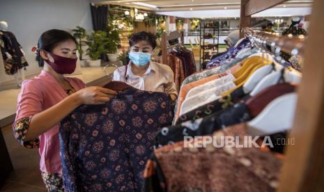 Karyawan melayani calon pembeli memilih pakaian yang terbuat dari kain jumputan di Palembang, Sumatera Selatan, Rabu (30/9/2020). Menteri Koperasi dan UKM Teten Masduki mengatakan realisasi penyaluran program Pemulihan Ekonomi Nasional (PEN) sektor UMKM telah mencapai lebih dari 70 persen dari total anggaran sebesar Rp123,46 triliun. 