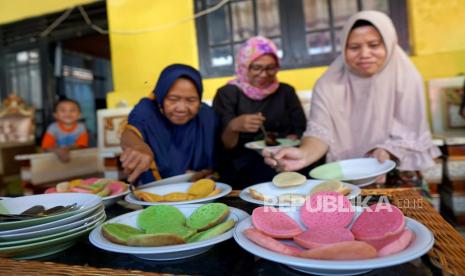 Sejumlah warga menikmati kue apangi di Dembe 1, Kota Gorontalo, Gorontalo, Kamis (27/7/2023). Masyarakat Dembe 1 menggelar Festival Apangi dalam rangka menyambut 10 Muharram tahun Hijriah dengan memasak dan membagikan kue kepada masyarakat dan pengunjung yang datang bertamu atau sekadar melintas secara gratis. 