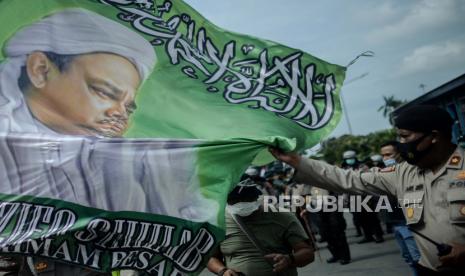 Aparat kepolisian mengamankan bendera bergambar HRS saat unjuk rasa 1812 Front Pembela Islam (FPI) di sekitar Patung Kuda Arjuna Wiwaha, Jakarta Pusat, Jumat (18/12). Saat ini beredar Surat Telegram Rahasia Kapolri yang menyebutkan bahwa FPI dilarang beraktivitas di Indonesia. (ilustrasi)