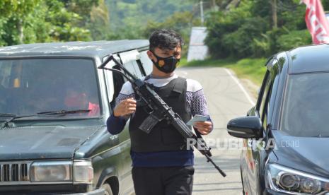 Petugas memeriksa KTP pengendara yang datang dari arah Riau saat melintas di Posko Penyekatan perbatasan provinsi, di Pangkalan, Kabupaten Limapuluhkota, Sumatera Barat.  Pemrov Sumbar bersama petugas gabungan TNI-Polri menyekat sembilan titik di pintu masuk ke provinsi itu, terutama pintu masuk dari zona merah Covid-19.  