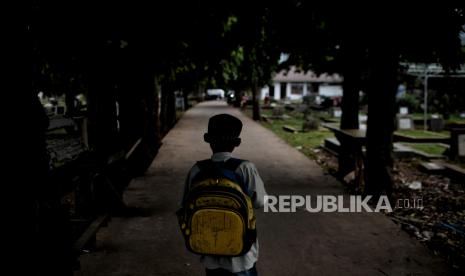 Anak bermain di kawasan Tempat Pemakaman Umum di Jakarta.