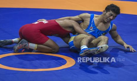 Ridwan Kamil Optimistis Jabar Juara PON Papua. Foto:   Pegulat putra Kalimantan Timur M. Aliansyah (kiri) berusaha mengunci pegulat putra Jabar Peri Budiawan (kanan) saat bertanding pada final Gulat Gaya Greco-roman kelas 67 Kg Putra PON Papua di Gor Futsal Dispora, Kabupaten Merauke, Papua, Rabu (13/10/2021). M. Aliansyah menang dan berhasil meraih medali emas. 