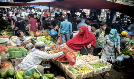 Pedagang saat melayani warga yang belanja di Pasar Minggu, Jakarta, Kamis (21/5). Meskipun sedang diberlakukannya masa Penerapan Sosial Berskala Besar, kini masyarakat mulai memadati pasar-pasar tradisional untuk membeli kebutuhan menyambut Hari Raya Idul Fitri