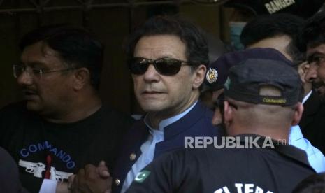 Mantan Perdana Menteri Pakistan Imran Khan (tengah) dikawal oleh petugas keamanan saat ia tiba untuk hadir di pengadilan, di Islamabad, Pakistan,12 Mei 2023. 