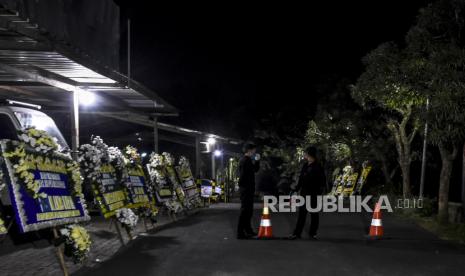 Petugas keamanan berjaga di depan pintu masuk rumah duka di Jalan Pagermaneuh, Lembang, Kabupaten Bandung Barat, Selas (30/6). Salah satu pendiri yang juga mantan Ketua Majelis Syuro Partai Keadilan Sejahtera (PKS) Hilmi Aminuddin meninggal dunia pada pukul 14.24 WIB pada usia 72 tahun, Almarhum dimakamkan di pemakaman keluarga dan sesuai dengan protokol penanganan Covid-19. Foto: Abdan Syakura/Republika