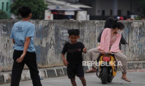 Warga berboncengan dengan posisi terbalik saat mengendarai sepeda listrik. Polisi menindak lebih dari lima orang pengemudi sepeda listrik, yang berada di jalan raya di kawasan Kota Bogor