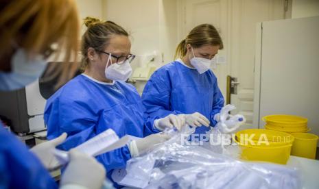 Teknisi laboratorium mengerjakan sampel COVID-19 di Institut biokimia medis dan diagnostik laboratorium di Rumah Sakit Universitas Umum di Praha, Republik Ceko. 