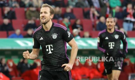 Pemain Munich Harry Kane melakukan selebrasi usai mencetak gol 3-1 dalam pertandingan sepak bola Bundesliga Jerman antara FC Augsburg dan FC Bayern Munich di Augsburg, Jerman,  Sabtu (27/1/2024).