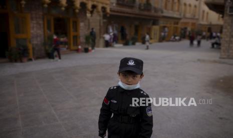 China Bantah Laporan Sebut Muslim Uighur Disiksa. Seorang anak laki-laki mengenakan kostum ala petugas keamanan SWAT di kawasan wisata bergaya kota tua yang baru dibangun di Hotan, Daerah Otonomi Uyghur Xinjiang, Cina, Kamis (29/4). Pusat wisata bergaya taman hiburan yang menampilkan budaya Muslim Uyghur itu tak pernah luput dari keamanan yang ketat. Xinjiang mendapatkan sumber pendapatan baru dari kawasan wisata tersebut yang ditargetkan lebih dari 200 juta pengunjung ke Xinjiang tahun ini dan 400 juta pada 2025. REUTERS/Thomas Peter   SEARCH 