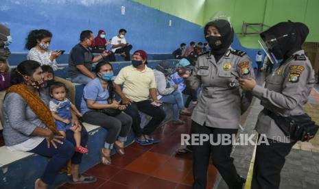 Petugas kepolisian mendata warga yang akan mengikuti tes cepat (rapid test) COVID-19 di Gelanggang Olahraga Tebet, Jakarta, Senin (23/11/2020). Polda Metro Jaya menyelenggarakan bakti sosial penyemprotan cairan disinfektan dan tes cepat atau rapid test COVID-19 karena adanya temuan kasus terkonfirmasi positif COVID-19 dari jemaah Maulid Nabi Muhammad SAW yang diselenggarakan di kawasan Tebet. 