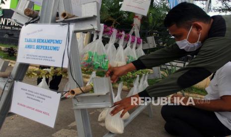 Warga menaruh bahan makanan di Stasiun Sedekah Kantor Kecamatan Pinang, Tangerang, Banten, Rabu (20/5/2020). Stasiun sedekah yang berisi sejumlah kebutuhan pokok disediakan oleh masyarakat yang ingin bersedekah terutama bagi warga terdampak COVID-19