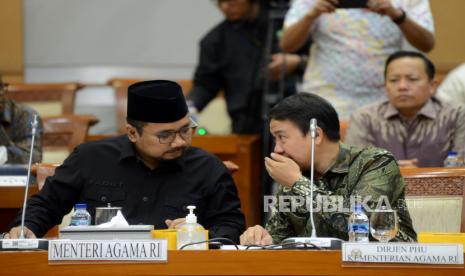 Menteri Agama Yaqut Cholil Qoumas (kiri) berbincang dengan Direktur Jenderal Penyelenggaraan Haji dan Umroh (PHU) Kementerian Agama Hilman Latief (kanan) sebelum mengikuti rapat kerja bersama Komisi VIII DPR di Kompleks Parlemen, Senayan, Jakarta, Rabu (17/5/2023). Rapat kerja tersebut membahas persiapan penyelenggaraan ibadah Haji 2023 serta membahas perubahan BPIH atas usulan penambahan kuota Haji 2023