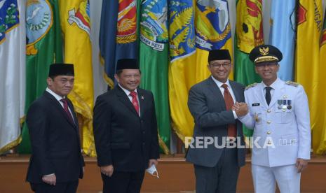 Penjabat Gubernur DKI Jakarta Heru Budi Hartono (kanan) berjabat tangan dengan mantan Gubernur DKI Jakarta Anies Baswedan (kedua kanan) disaksikan Menteri Dalam Negeri Tito Karnavian (kedua kiri) dan mantan Wakil Gubernur Ahmad Riza Patria (kiri) usai dilantik di Kementerian Dalam Negeri, Jakarta, Senin (17/10/2022). Heru Budi Hartono sah dilantik sebagai Penjabat (Pj) Gubernur DKI Jakarta menggantikan Anies Baswedan dan Ahmad Riza Patria yang purnatugas. Prayogi/Republika. 