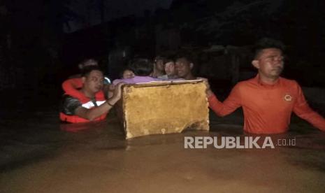  Dalam foto yang disediakan oleh Penjaga Pantai Filipina ini, tim penyelamat menggunakan pelampung darurat saat mereka mengevakuasi penduduk dari air banjir yang disebabkan oleh Badai Tropis Nalgae di Zamboanga, Filipina selatan pada Sabtu 29 Oktober 2022. Banjir bandang dan tanah longsor yang dipicu oleh hujan deras meninggalkan lusinan orang tewas, termasuk di provinsi Filipina selatan yang terkena dampak parah, di mana banyak penduduk desa dikhawatirkan hilang dan terkubur dalam banjir air hujan, lumpur, batu dan pepohonan, kata para pejabat Sabtu.