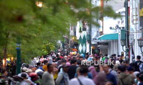 Wisatawan menghabiskan waktu di jalur pedesterian Malioboro, Yogyakarta. Kawasan tugu, Malioboro dan keraton (Gumaton) jadi favorit wisatawan di Yogyakarta.