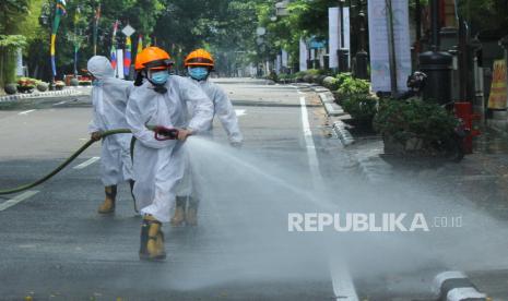 Petugas Dinas Kebakaran dan Penanggulangan Bencana Kota Bandung, menyemprotkan cairan disinfektan di trotoar, Jalan Merdeka, Selasa (22/9). Sebanyak 299 orang di Kota Bandung dinyatakan positif covid-19 dengan status tanpa gejala yang berasal dari 109 kepala keluarga atau masuk ke dalam klaster keluarga.