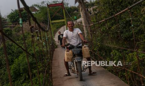 Warga membawa jerigen berisi air dari Sungai Ciberang di Desa Bungur Mekar, Lebak, Banten, Ahad (3/8/2023). Menurut warga setempat, sejak dua bulan terakhir air sumur di daerah tersebut mengalami kekeringan sehingga warga terpaksa memanfaatkan aliran Sungai Ciberang untuk kegiatan mandi, cuci dan kakus (MCK). 