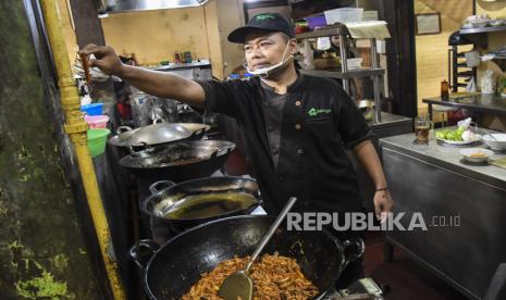 Seorang juru masak memasak dengan kompor yang dialiri bahan bakar gas bumi Perusahaan Gas Negara (PGN) di dapur rumah makan Ponyo, Bekasi, Jawa Barat, Selasa (29/12/2020). PGN menargetkan jaringan distribusi gas bumi untuk rumah tangga (jargas) mencapai 4 juta sambungan rumah (SR) pada tahun 2024 dan berkomitmen menyediakan sumber energi yang bersih serta ekonomis untuk pelanggan Usaha Mikro Kecil Menengah (UMKM) melalui program Gas Kita. 