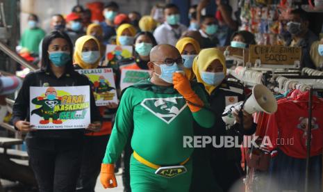 Camat Sawahan Yunus yang berperan sebagai tokoh New Man didampingi sejumlah anggota BPB Linmas Kota Surabaya mengimbau para pedagang dan pengunjung untuk selalu menerapkan protokol kesehatan saat melakukan sosialisasi di Pasar Kapasan, Surabaya, Jawa Timur, Senin (4/1/2021). Kegiatan tersebut bertujuan untuk mengingatkan masyarakat agar tetap mematuhi protokol kesehatan seperti menggunakan masker, mencuci tangan dan menjaga jarak guna mencegah penyebaran COVID-19. 