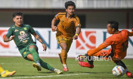 Pesepak bola Persebaya Surabaya Bruno Moreira (kiri) menendang bola dengan dihadang pesepak bola Bhayangkara FC Mochamad Rifky Ananta (tengah) dalam lanjutan pertandingan Liga 1 di Stadion Patriot Chandrabhaga, Bekasi, Jawa Barat, Selasa (8/8/2023).  