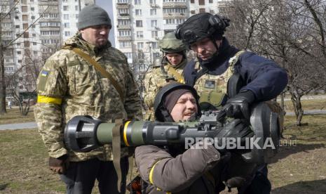 Anggota Pasukan Pertahanan Teritorial Ukraina berlatih menggunakan senjata anti-tank NLAW di pinggiran Kyiv, Ukraina, Rabu, 9 Maret 2022. Pihak berwenang mengumumkan gencatan senjata baru pada hari Rabu untuk memungkinkan warga sipil melarikan diri dari kota-kota di sekitar ibu kota, Kyiv, serta kota-kota selatan Mariupol, Enerhodar dan Volnovakha, Izyum di timur dan Sumy di timur laut. Upaya sebelumnya untuk membangun koridor evakuasi yang aman sebagian besar gagal karena serangan oleh pasukan Rusia.