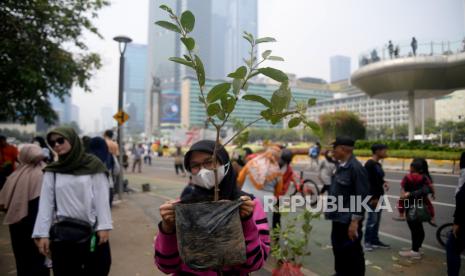 Warga mengambil bibit pohon gratis saat Hari Bebas Kendaraan Bermotor (HBKB) di Kawasan Bundaran HI, Jakarta, Ahad (1/10/2023). Acara yang bertajuk Gotong Royong Boyong Pohon yang diselenggarkan oleh Kementerian BUMN itu digelar dengan membagikan bibit pohon gratis yang terdiri dari jeruk, mangga, jambu, durian, dll itu kepada masyarakat. Tujuan gerakan sosial ini adalah menanam pohon sebanyak-banyaknya untuk mengurangi polusi udara di Jakarta dan sekitarnya di masa depan.