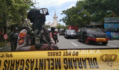 Petugas kepolisian berjaga di lokasi dugaan bom bunuh diri di depan Gereja Katedral Makassar, Sulawesi Selatan, Minggu (28/3/2021). 