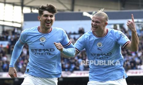 Pemain Manchester City John Stones (kiri) berselebrasi dengan rekan setimnya Erling Haaland setelah mencetak gol pembuka timnya pada pertandingan sepak bola Liga Premier Inggris antara Manchester City dan Leicester City di Stadion Etihad di Manchester, Inggris, Sabtu (15/4/2023). 