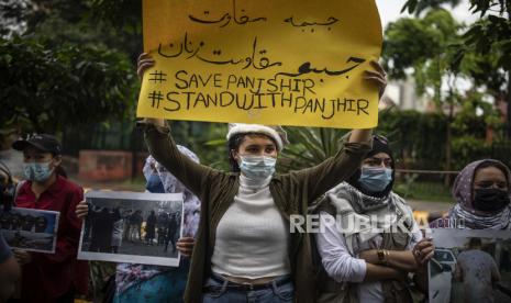  Wanita Afghanistan memegang plakat selama protes terhadap Pakistan dan pengambilalihan Taliban atas Afghanistan, di New Delhi, India, Kamis, 16 September 2021.