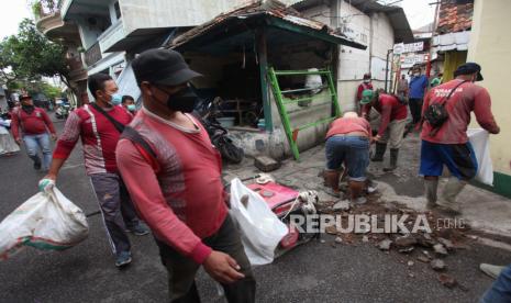 Sejumlah petugas melakukan kerja bakti di kawasan Nyamplungan Balokan, Surabaya, Jawa Timur, Ahad (30/1/2022). Kerja bakti yang dilakukan di 31 Kecamatan di Surabaya  tersebut melibatkan  warga serta pegawai Pemkot Surabaya untuk mewujudkan lingkungan yang bersih, mencegah genangan air pada musim penghujan, dan mengantisipasi adanya nyamuk Demam Berdarah Dengue (Aedes Aegypti). 