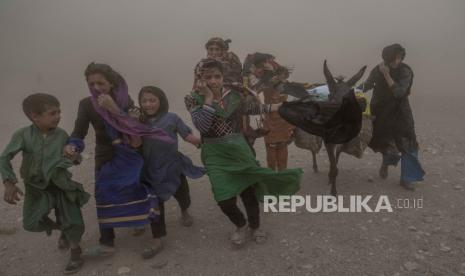 Anak perempuan dan perempuan Afghanistan membawa bantuan sumbangan ke tenda mereka, setelah gempa bumi di distrik Zenda Jan, (12/10/2023).