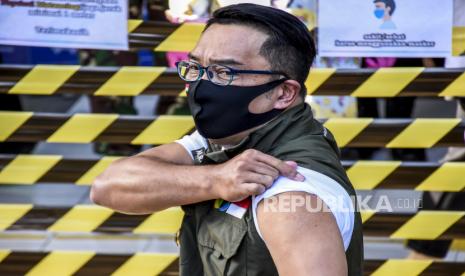 Gubernur Jawa Barat Ridwan Kamil menunjukkan bekas suntikan vaksin usai menjalani kunjungan tahap kedua Uji Klinis Vaksin Covid-19 di Puskesmas Garuda, Jalan Dadali, Kota Bandung, Jumat (28/8). Gubernur Jawa Barat Ridwan Kamil bersama Kapolda Jabar Irjen Rudy Sufahriadi, Pangdam III/Siliwangi Mayjen TNI Nugroho Budi Wiryanto dan Kepala Kejati Jabar Ade Eddy Adhyaksa menjalani tahap kedua uji klinis fase tiga vaksin Covid-19 berupa penyuntikan vaksin. Foto: Abdan Syakura/Republika