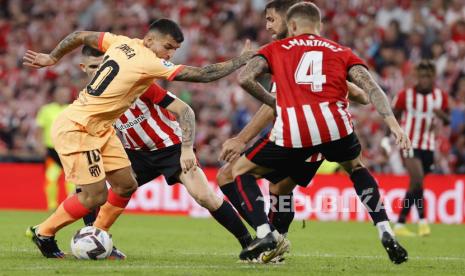 Bek Athletic Bilbao Yeray Alvarez (2-kanan) dan Inigo Martinez (kanan) beraksi melawan striker Atletico Madrid Angel Correa (kiri) selama pertandingan sepak bola LaLiga Spanyol antara Athletic Bilbao dan Atletico Madrid yang diadakan di Stadion San Mames, di Bilbao, Basque Country , Spanyol utara, 15 Oktober 2022.